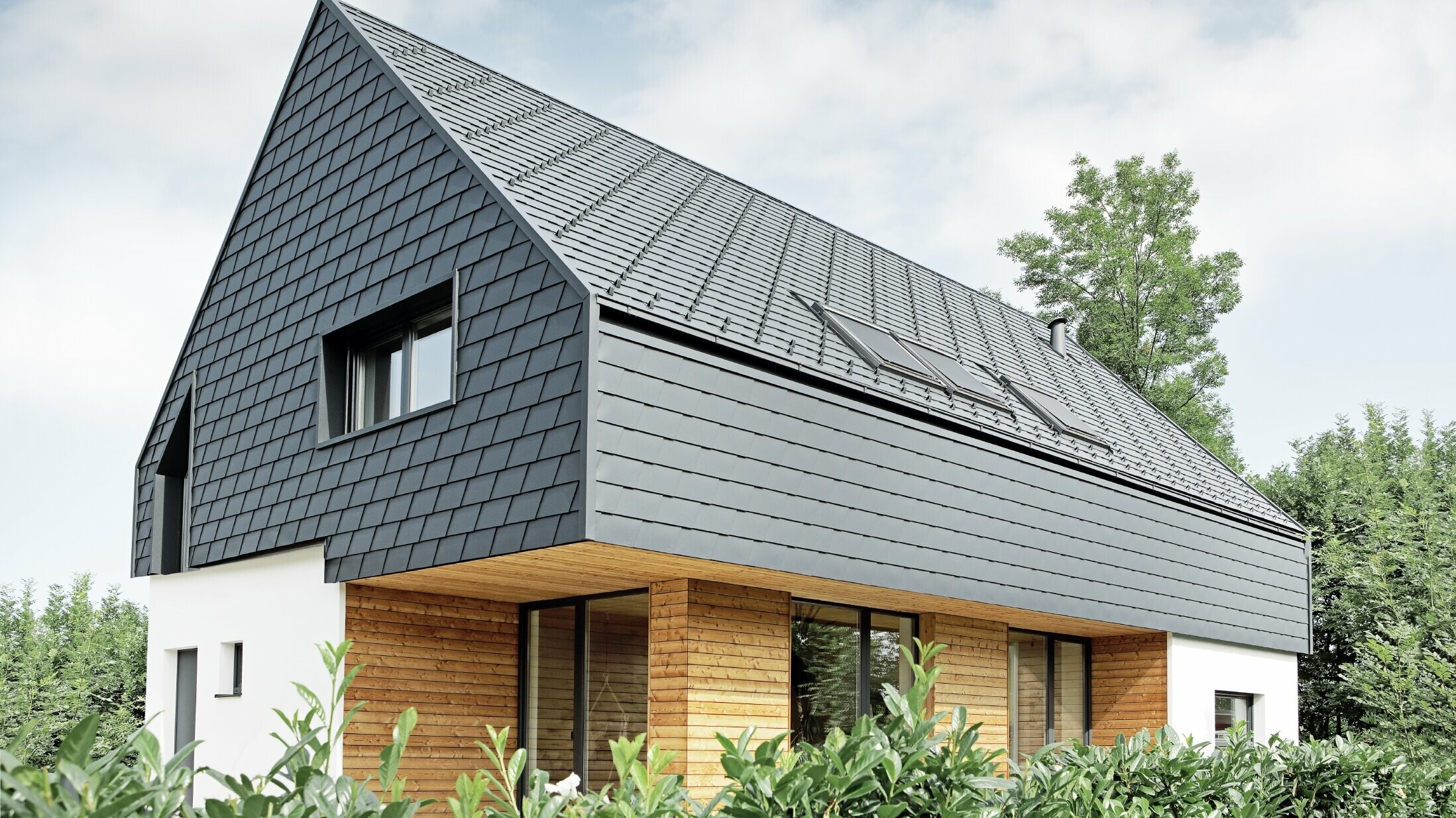 Einfamilienhaus mit Satteldach, eingedeckt mit der PREFA Schindel in P.10 Anthrazit, auch an der Fassade im Obergeschoß und am Giebel wurde die Schindel verlegt
