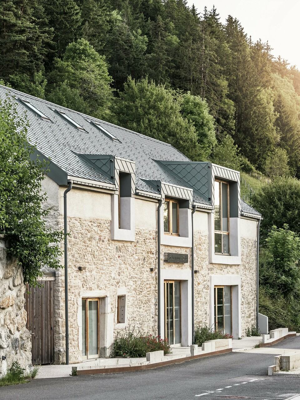 Die restaurierte Scheune "La Grange à Gaby" in Engins, Frankreich. Das Gebäude kombiniert traditionelles Steinemauerwerk mit einem modernen PREFA Aluminiumdach aus 29 × 29 cm großen Rauten. Die Sanierung verbindet historische Bauweise mit zeitgemäßer Architektur und nachhaltigen Materialien.