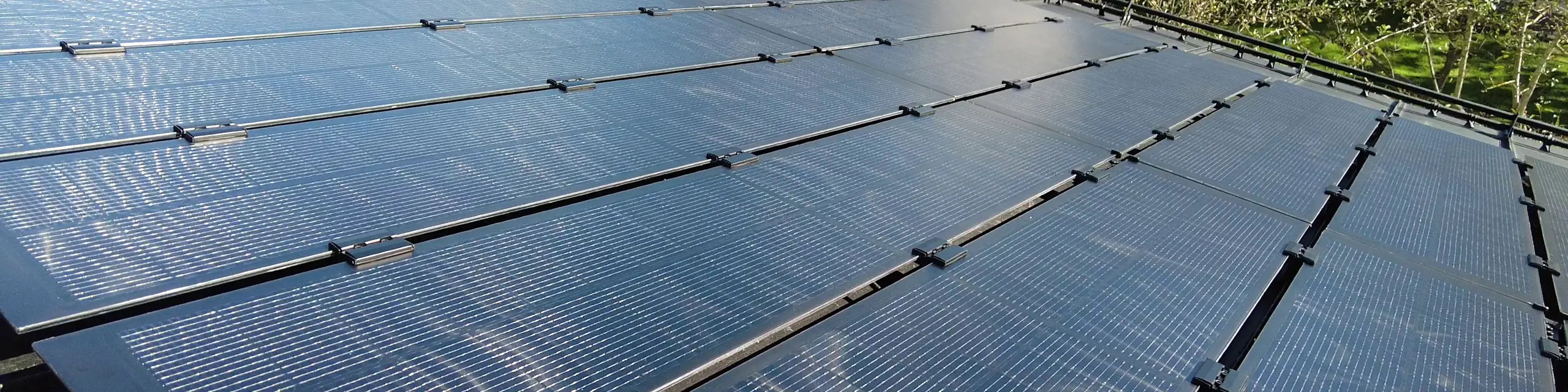 Ansicht eines mit PREFALZ Solarmodulen ausgestatteten Dachs, mit Glas/Glas PV-Modulen, die präzise an die Falzbreiten der Doppelstehfalzbahnen angepasst sind.