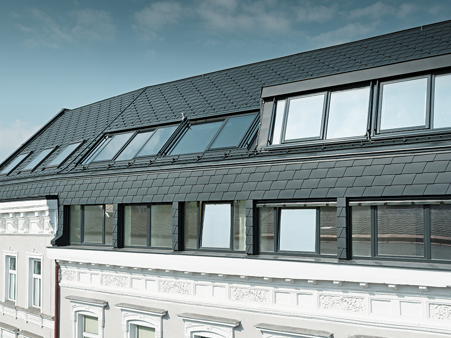 Dachgeschossausbau einer Wohnhausanlage in Wien mit der Dachschindel in P.10 Anthrazit