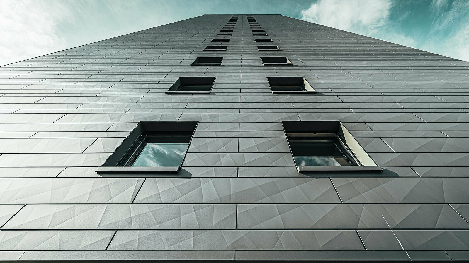 PREFA Fassadensidings am Hochhaus Erfstadt mit schönen Kontrast zum blauen Himmel im Hintergrund des Bildes.