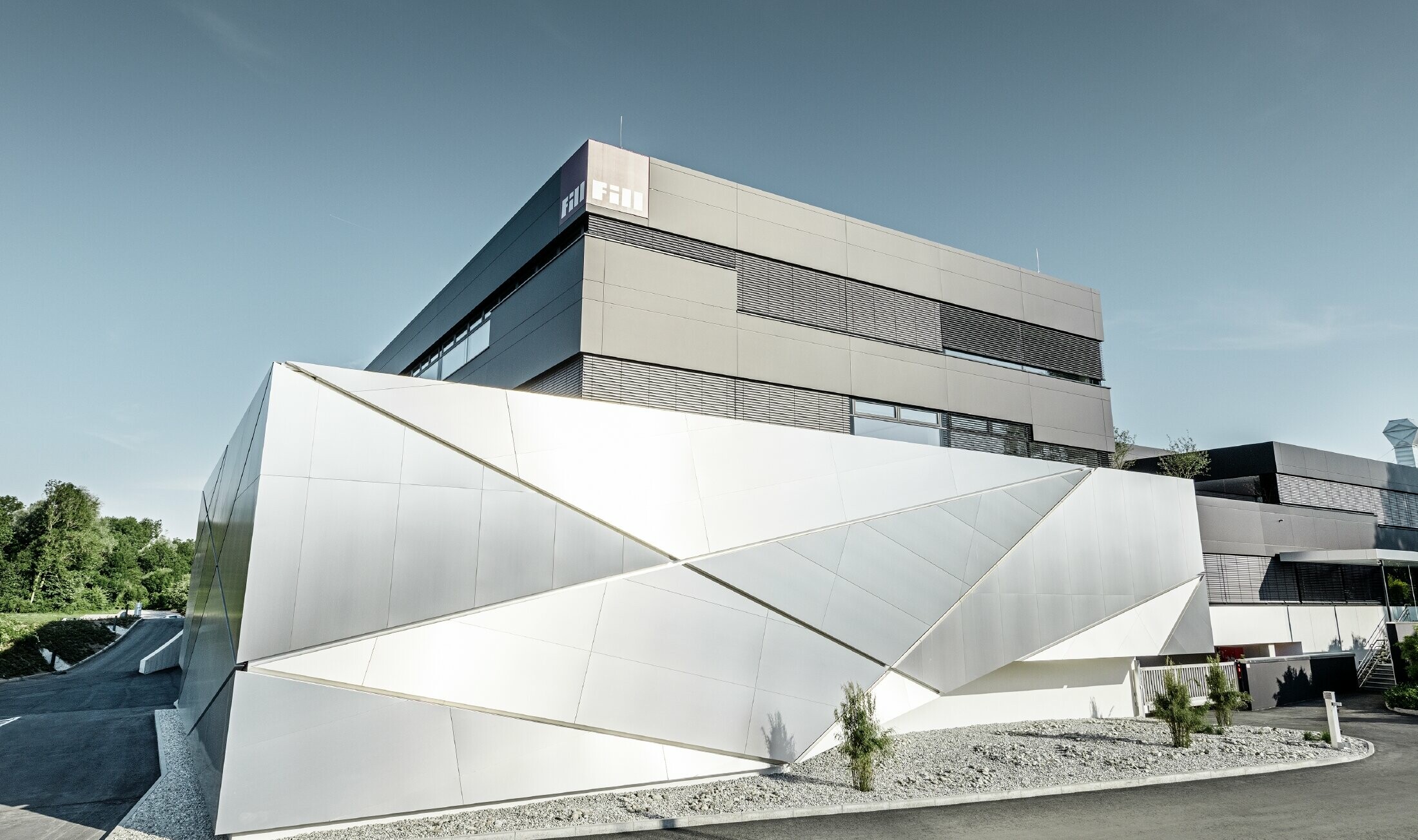 Fill Firmengebäude mit futurischer Aluminium Verbundplattenfassade in aluminium gebürstet und hinterleuchtetem Fugenbild