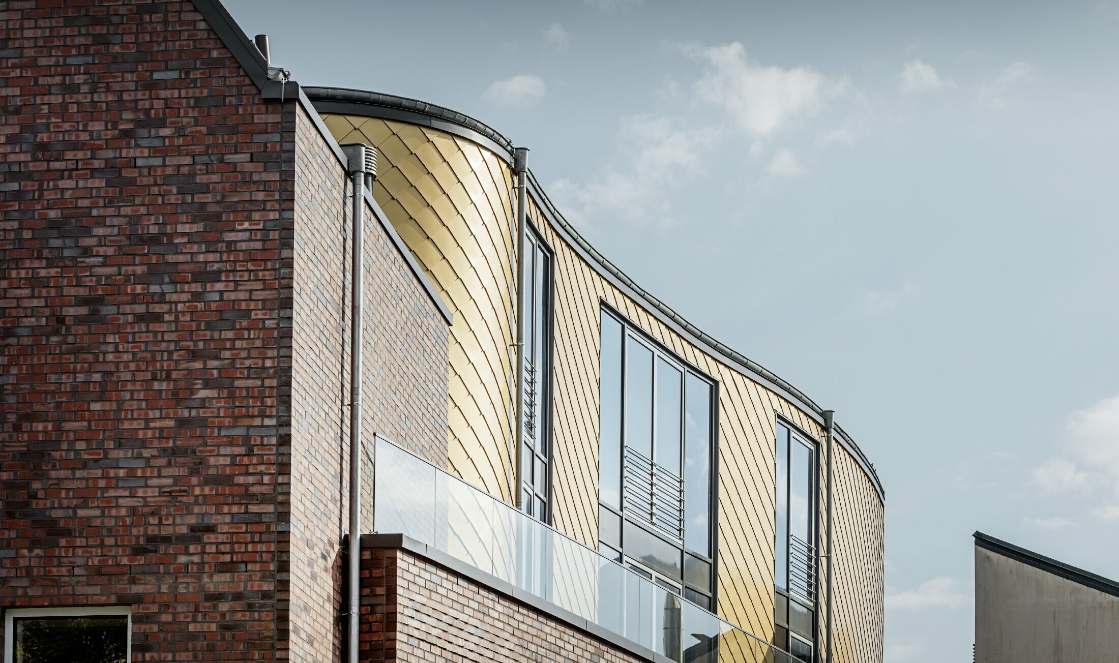 Geschwungene Fassade des Schuhhaus Schüttfort; Die Fassade wurde mit der Aluminium Raute von PREFA in Mayagold bekleidet.