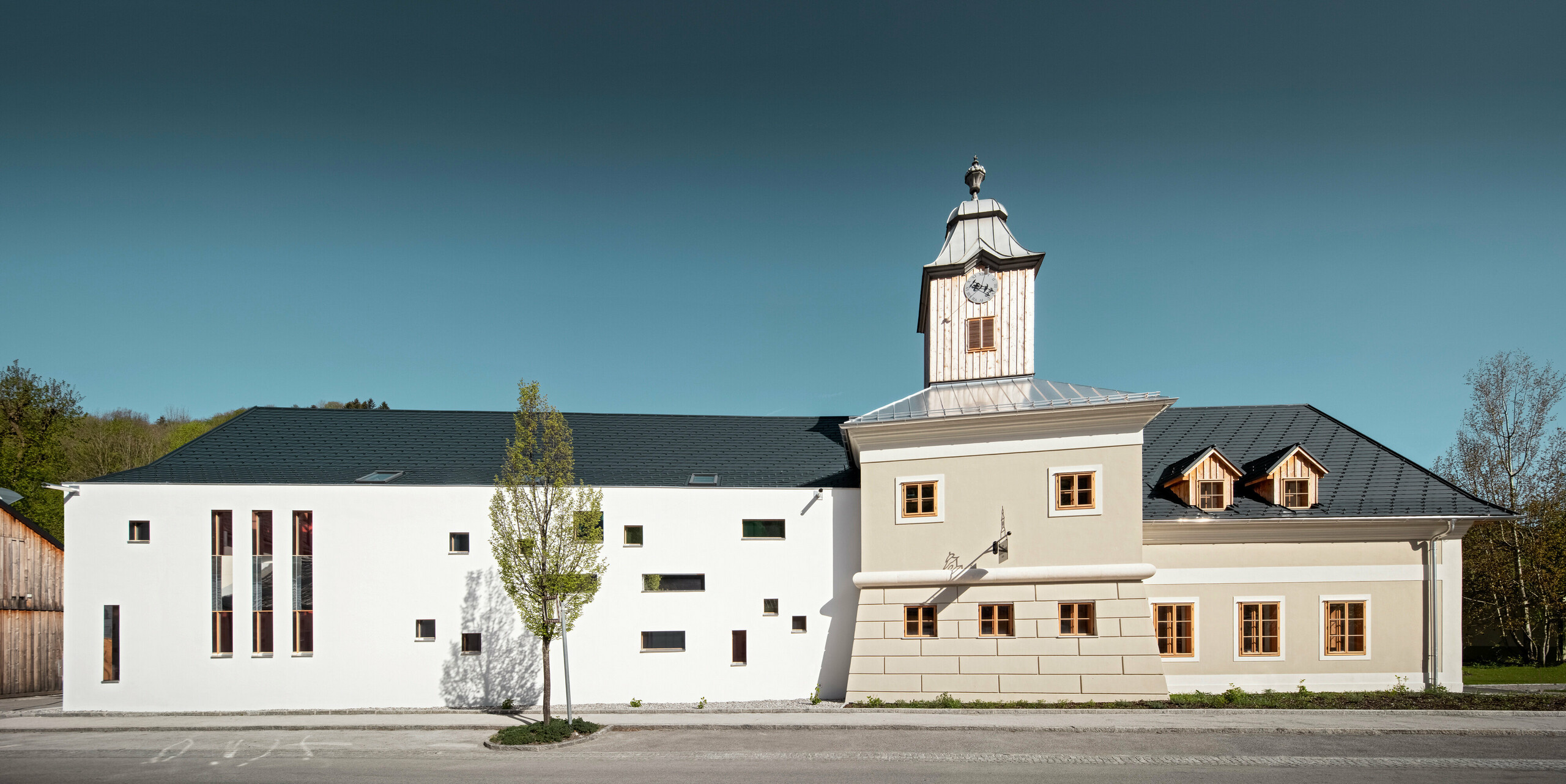 Das Dach des Hotels Glockenturm in Marktl bei Lilienfeld wurde mit der PREFA Dachschindel in P.10 Anthrazit verkleidet. Das PREFA Dachentwässerungssystem des Gebäudes ist in Naturblank gehalten. Unweit vom Hotel Glockenturm liegt das Leopold - unser Wirtshaus. Das Restaurantgebäude wurde ebenfalls mit PREFA Produkten eingedeckt.