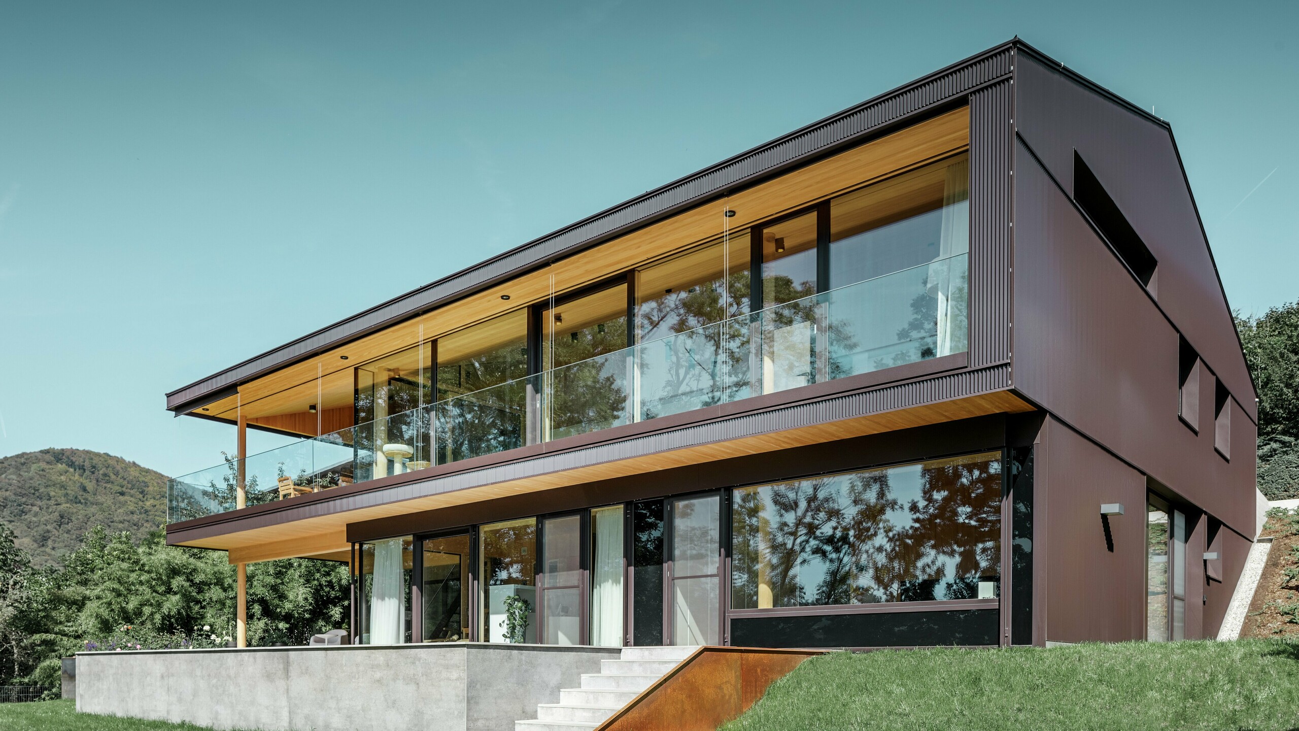 Dieses moderne Einfamilienhaus in Linz verfügt über eine großzügige Terrasse und große Fenster auf der Gartenseite. Die Fassade wurde mit PREFA Zackenprofil in Nussbraun verkleidet. Die einzigartige Fassade aus stranggepresstem Aluminium verändert ihr Erscheinungsbild je nach Lichteinfall und verleiht dem Objekt einen einzigartigen Look.