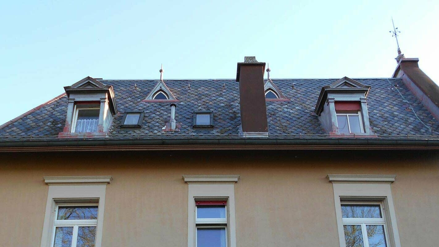 altes Dach mit verspielten Gauben vor der Dachsanierung mit der PREFA Dachraute
