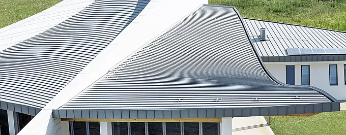 Seitliche Ansicht der geschwungenen Dachform der Madonna Kirche in Jesolo, eingedeckt mit PREFALZ in Patinagrau.