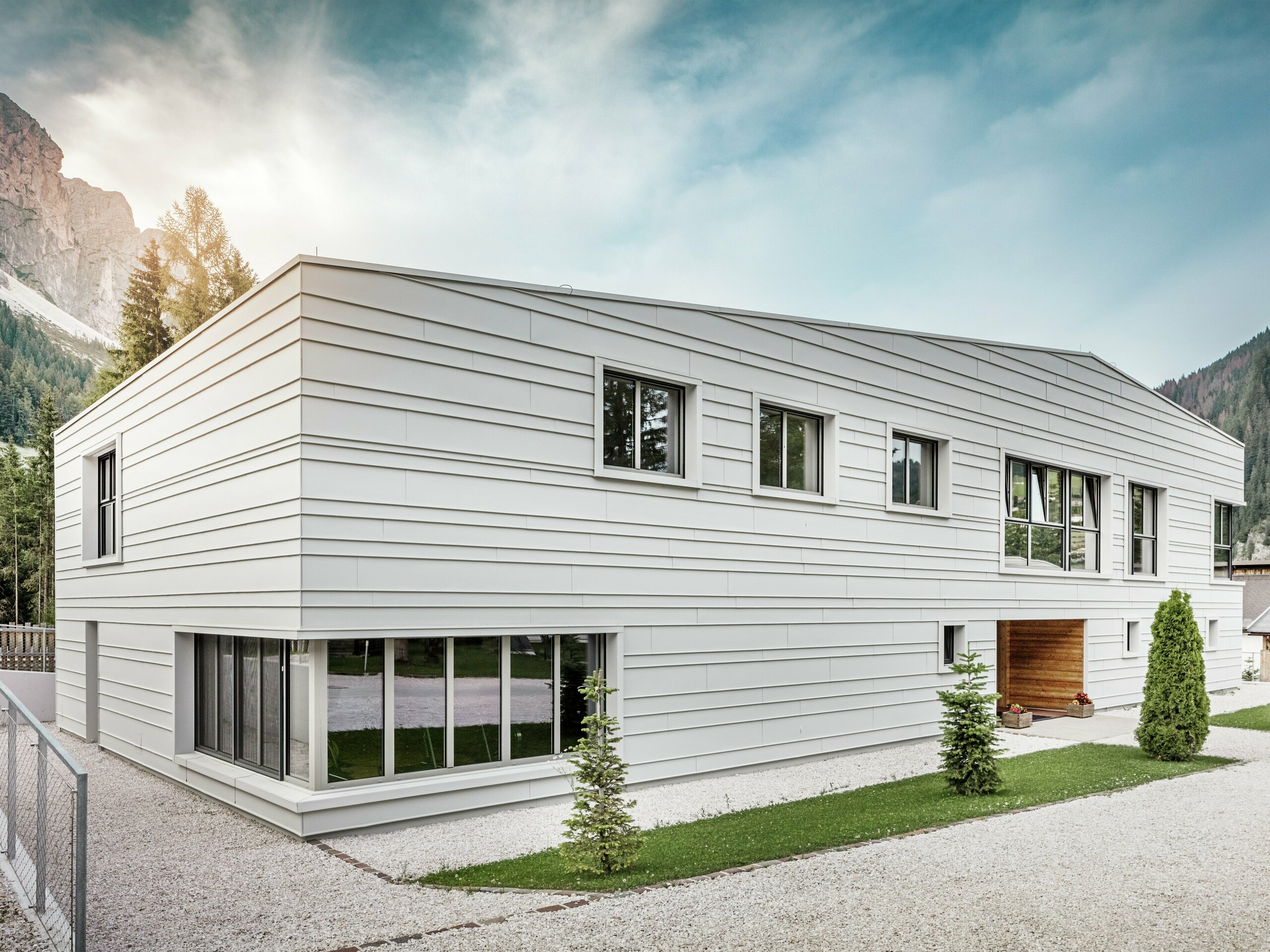 Die moderne Fassade der Kaserne „Tempesti“ in Südtirol besticht durch ihre klare Geometrie und die hochwertigen Stehfalzbahnen aus PREFALZ in der Farbe P.10 Prefaweiß. Das verwendete Aluminium reflektiert das Licht, reguliert das Mikroklima und bietet dauerhaften Schutz. Ein echter Eyecatcher ist der holzverkleidete Eingangsbereich, der Wärme und Offenheit in die strenge Militärumgebung bringt.