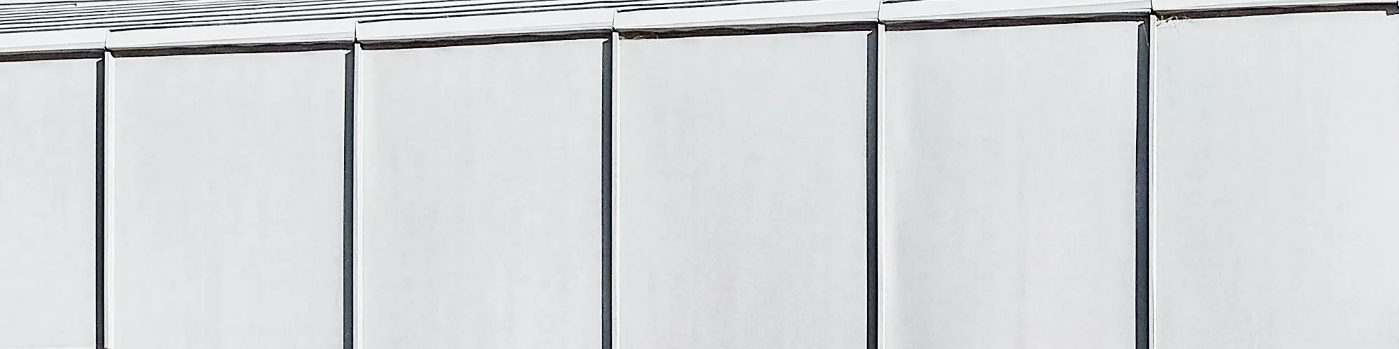 Die matt-graue Aluminiumhülle des Hauses mit gleichmäßigem Rhythmus aus nächster Nähe.