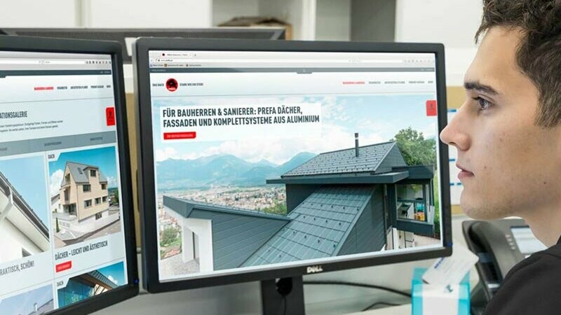 PREFA Schüler / Student arbeitet an PREFA Website an einem Arbeitplatz mit zwei Computern