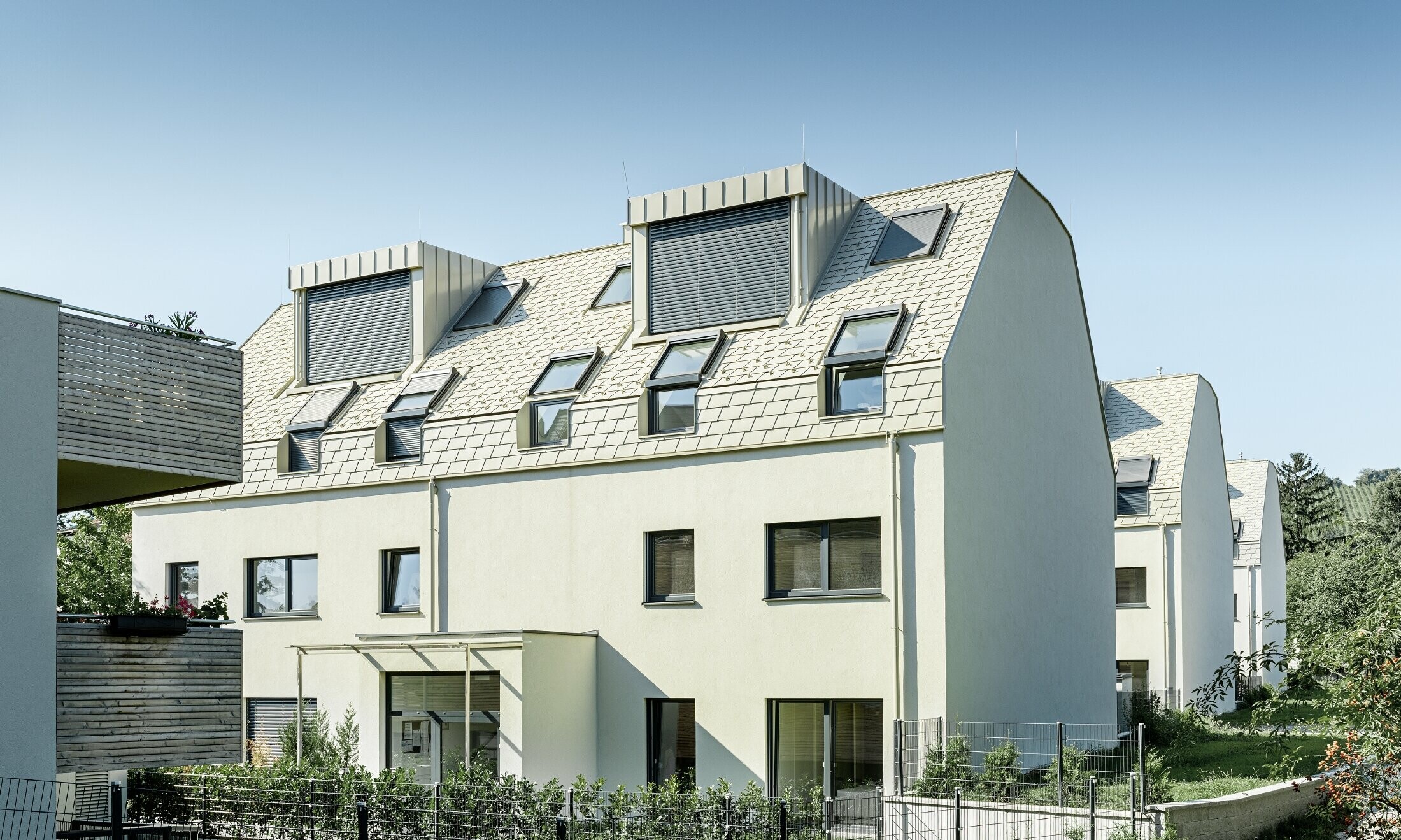 neue Wohnhausanlage mit großer Aluminium Dachfläche und vielen Dachflächenfenstern 