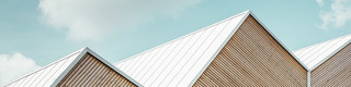 Detail Dachlandschaft des Projekts "Hausfuchs" in Vaterstetten nahe München, weiße Prefalz-Bahnen und Holzfassade bilden feine Linien.
