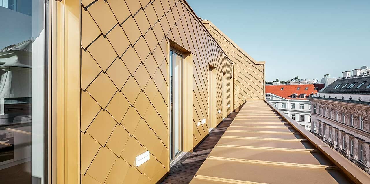 Ausgebautes Dachgeschoss der Bandstätte in Wien, verkleidet mit der Wandraute 29 × 29 in Perlgold.