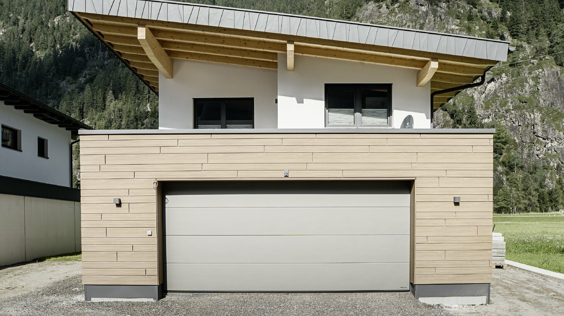 Moderner Neubau mit Pultdach und individueller Ortgangverblechung, Garage mit Flachdach und Alu-Fassade in Walnuss braun von PREFA. Die Sidings wurden horizontal verlegt und mit unterschiedlichen Baubreiten.
