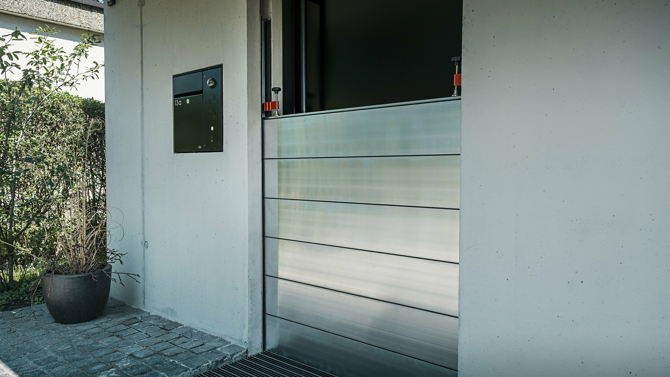 Komplettmontage des PREFA Hochwasserschutzes an der Eingangstüre eines Einfamilienhauses in Lustenau. Die formschöne Integration der Aluminiumprofile schützt das Gebäude im Ernstfall vor Hochwasser und sorgt für eine ansprechende Optik.
