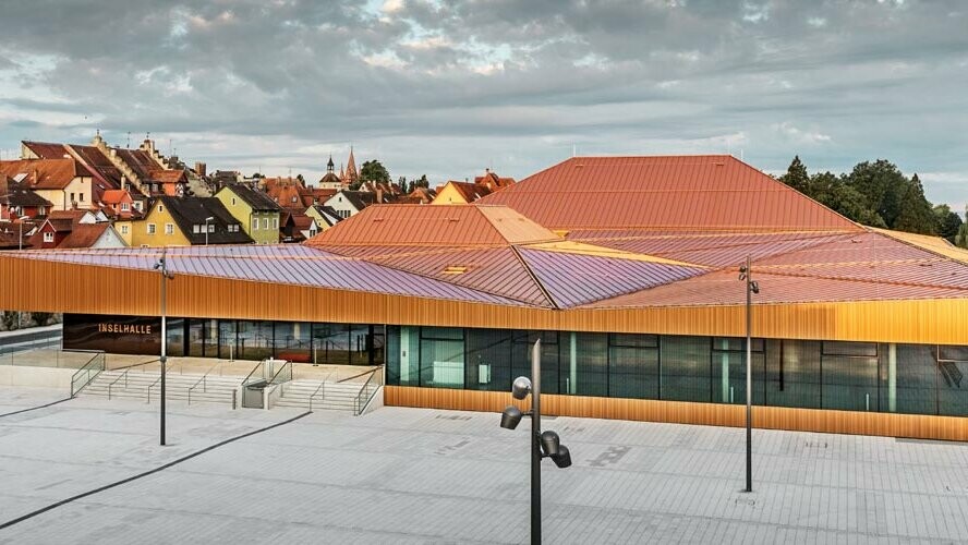 Deutsche Veranstaltungshalle mit PREFA Falzonal an Dach und Fassade in einer Sonderfarbe, ähnlich neukupfer