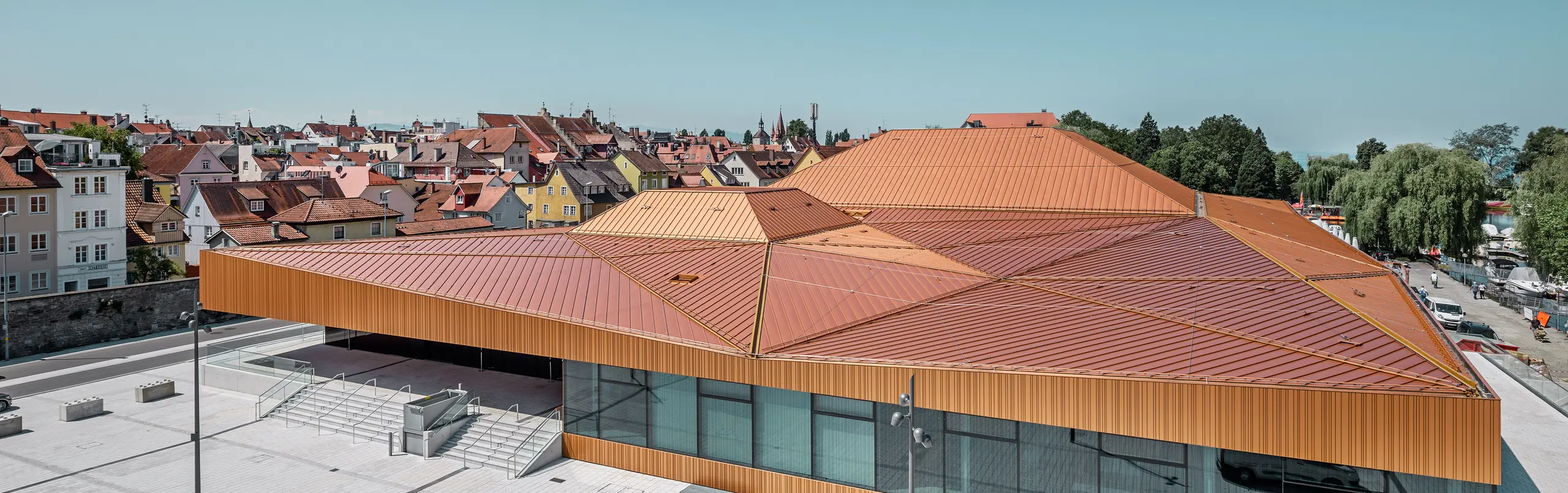 Deutsche Veranstaltungshalle mit PREFA Falzonal an Dach und Fassade in einer Sonderfarbe, ähnlich neukupfer