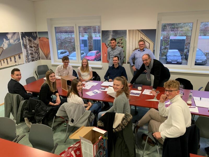 Die Schüler und Schülerinnen sitzen in der Zentrale gemeinsam mit Michael Birwipfel, Michael Strasser, Sebastian Mohrwind und Christian Neureiter in Marktl zusammen.