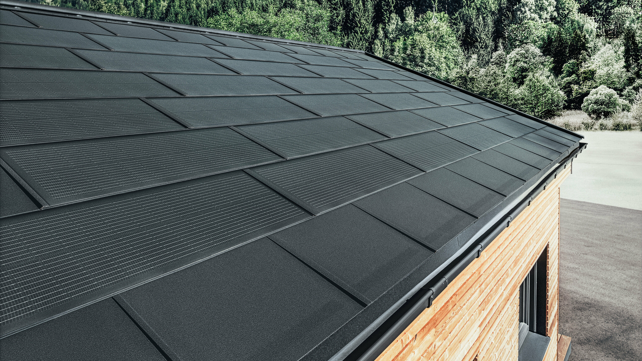 PREFA Solardachplatte in großer Ausführung kombiniert mit der Dachplatte R.16 in Schwarz, Kastenrinne und Lärchenholz-Fassade