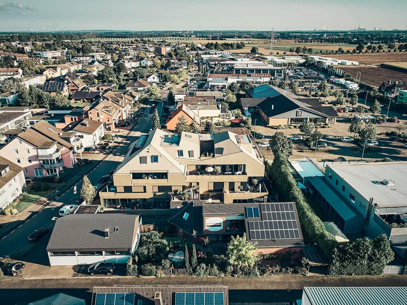 Vogelperspektive des Erftstädter Wohnhauses mit der deutlich erkennbaren Rautenfassade und den P.10. Bronzedachziegeln von PREFA.