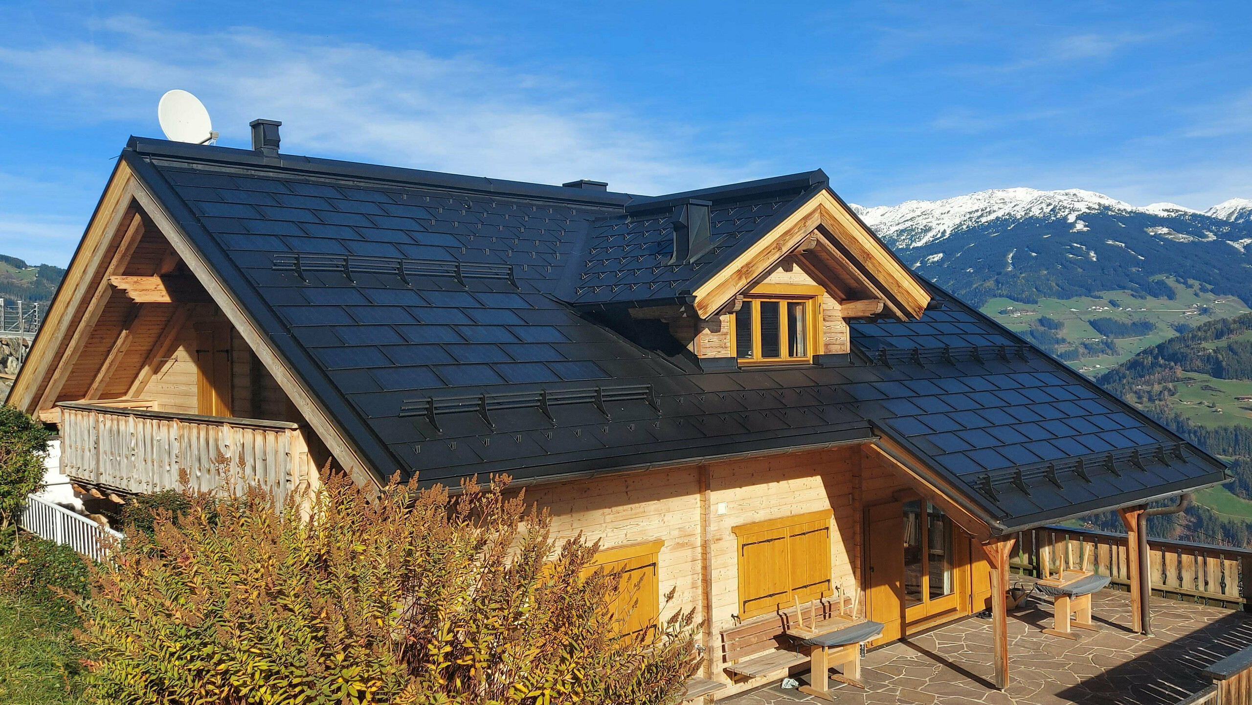 Sanierung eines Einfamilienhauses in Hippach (Tirol) mit der PREFA Solardachplatte klein in P.10 Schwarz, kombiniert mit der PREFA Dachplatte R.16