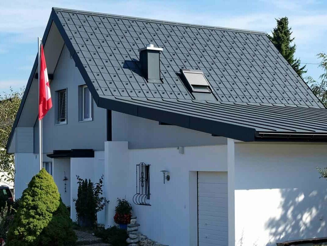 Haus mit Garage nach der Dachsanierung mit der PREFA Dachplatte in Anthrazit