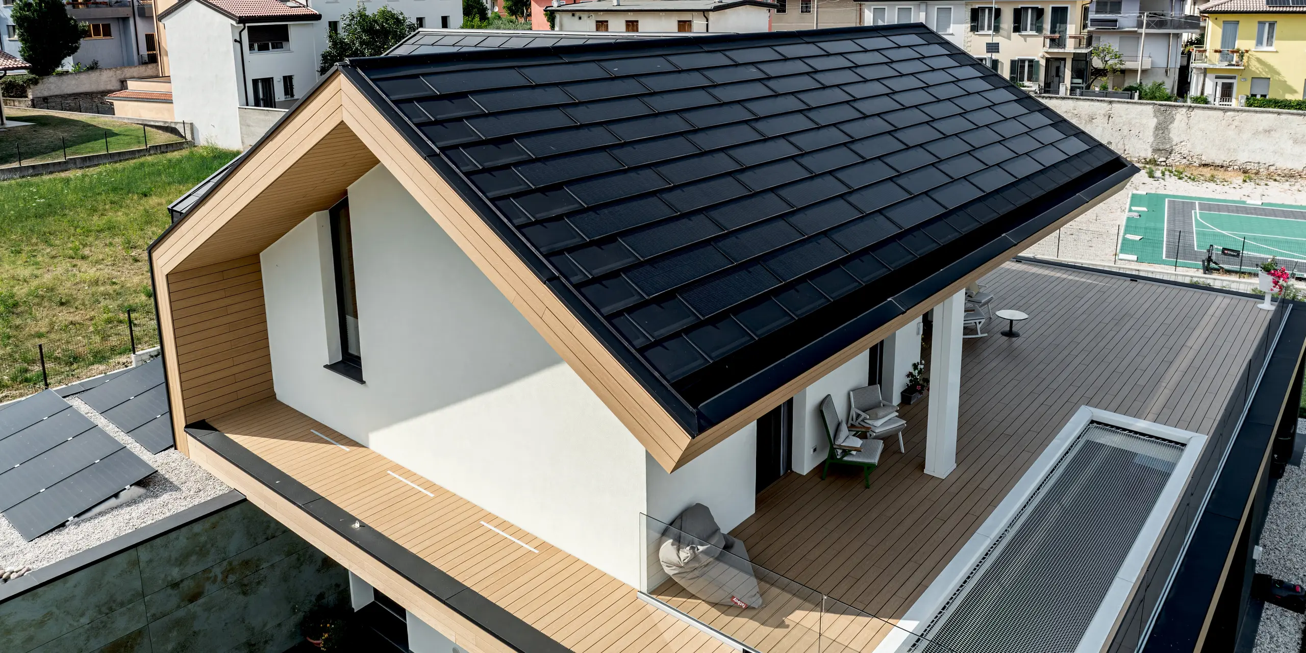 Detailansicht eines modernen Einfamilienhauses in Vicenza mit PREFA Solardachplatte und Dachplatte R.16 in P.10 Schwarz. Die elegante Aluminiumdeckung mit klarer Linienführung prägt die Architektur und integriert innovative Photovoltaikmodule. PREFA Produkte überzeugen durch langlebigen Witterungsschutz, hohe Qualität und eine harmonische Verbindung von Funktionalität und modernem Design.