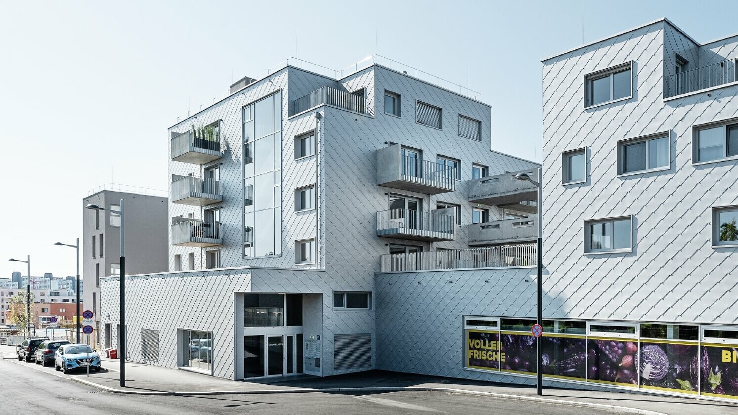 Wohnhausanlagen mit Flachdach und Rautenverkleidung an der Fassade mit der PREFA Wandraute 44 × 44 in Silbermetallic