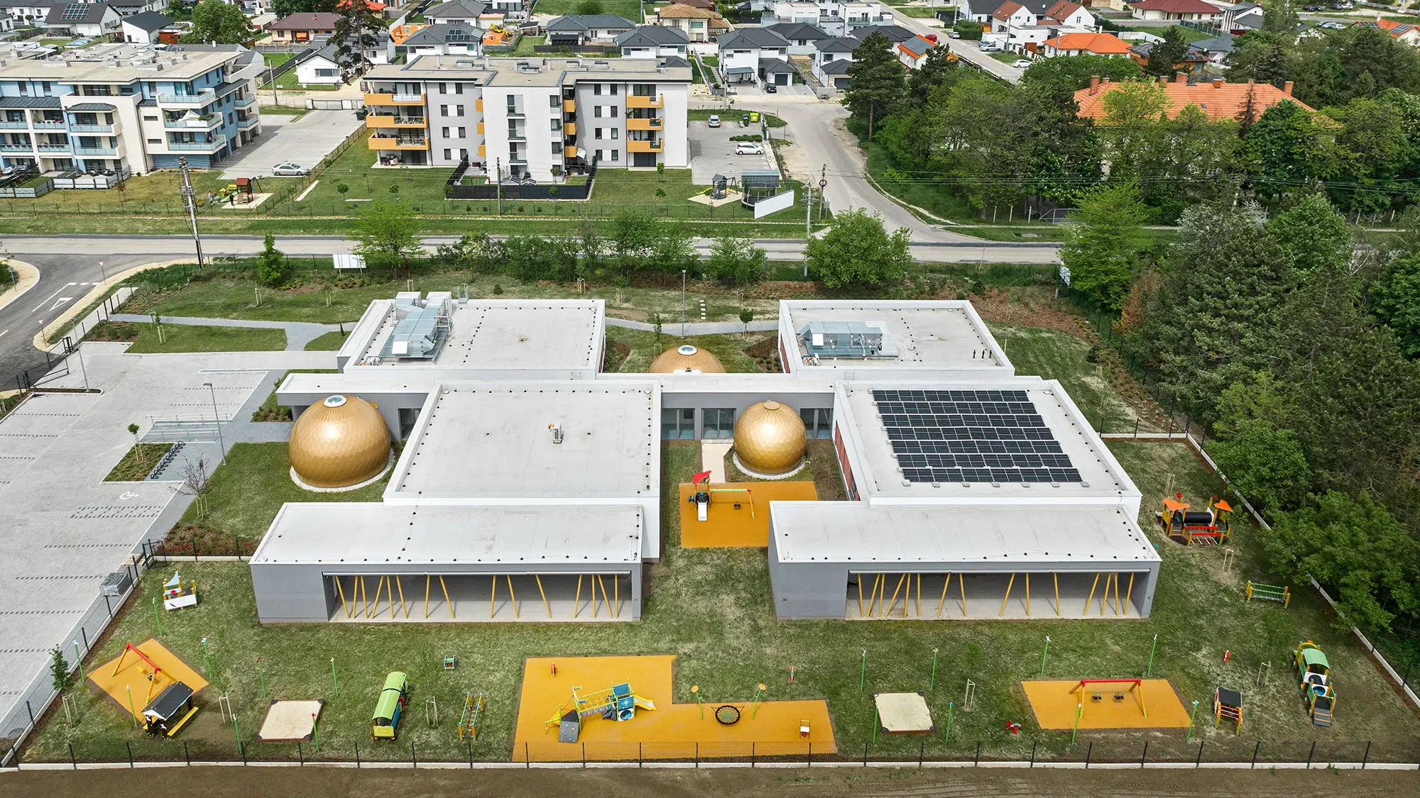 Die gesamte Kinderkrippe sowie ihre unmittelbare Umgebung aus der seitlichen Vogelperspektive.