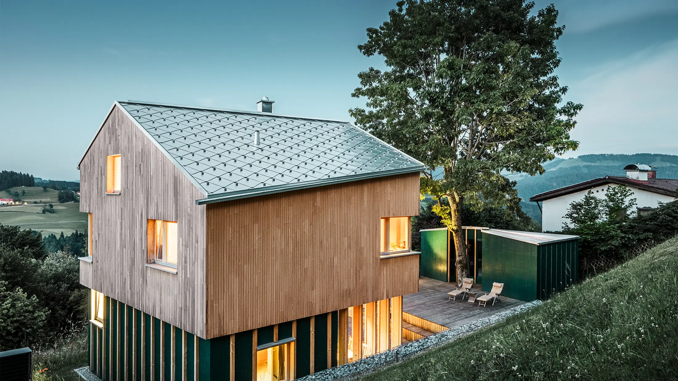 Neugebautes Einfamilienhaus mit Holzfassade und naturblankem PREFA Dach in Rautenform