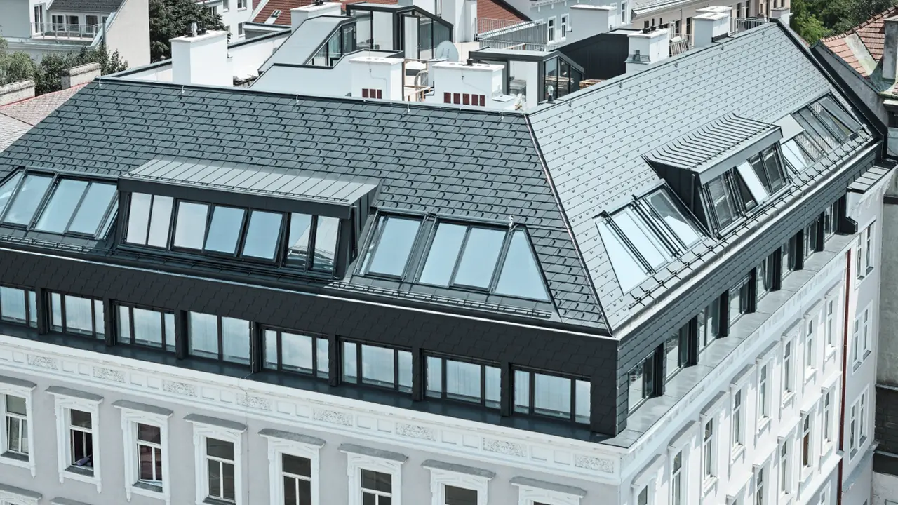Dachgeschoßausbau eines Wohnhauses in Wien Mariahilf, das Dachgeschoß wurde mit Penthouse Wohnungen ausgebaut; Das Dach wurde mit PREFA Dachschindeln in Anthrazit verkleidet.