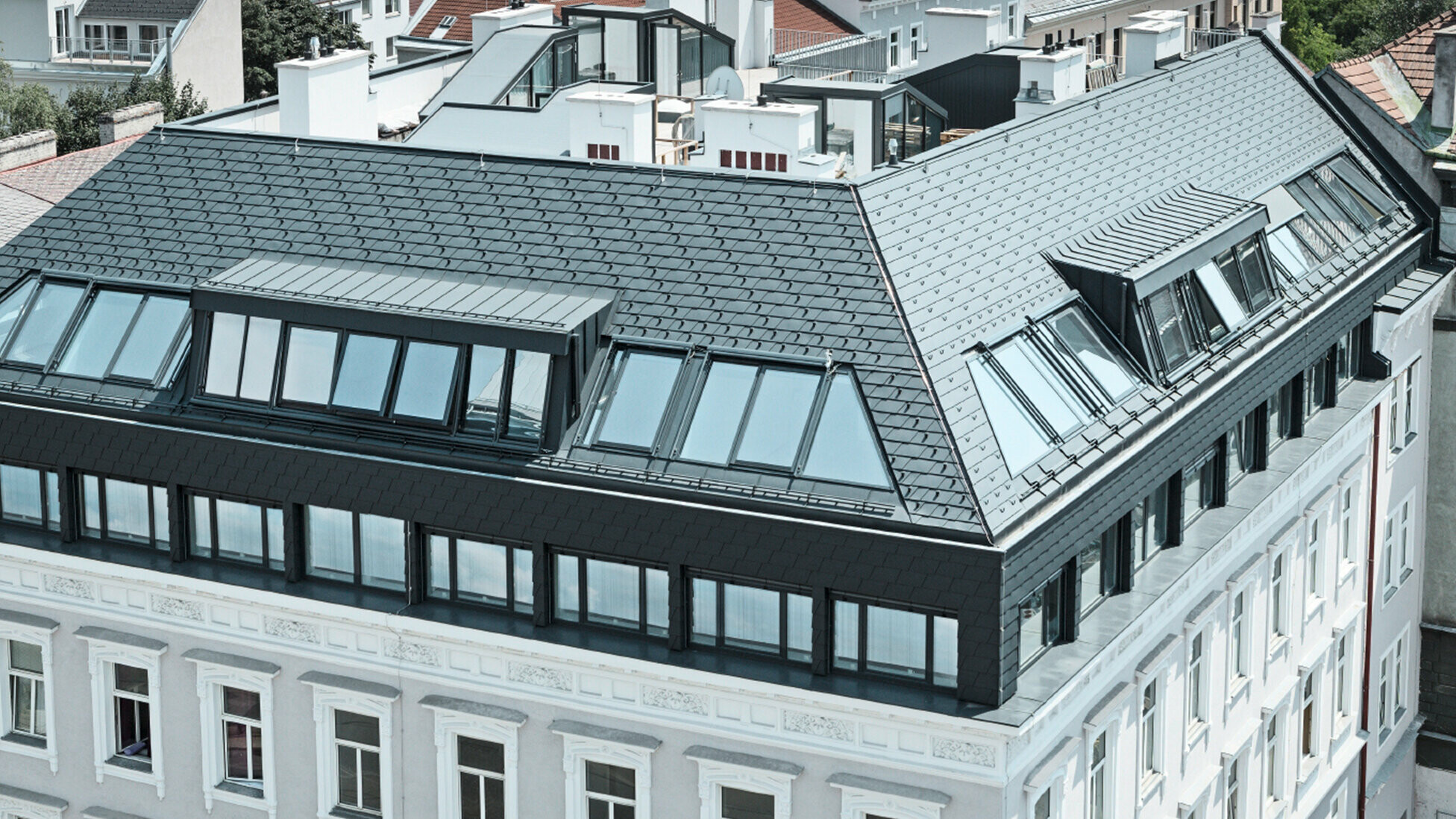 Dachgeschoßausbau eines Wohnhauses in Wien Mariahilf, das Dachgeschoß wurde mit Penthouse Wohnungen ausgebaut; Das Dach wurde mit PREFA Dachschindeln in Anthrazit verkleidet.