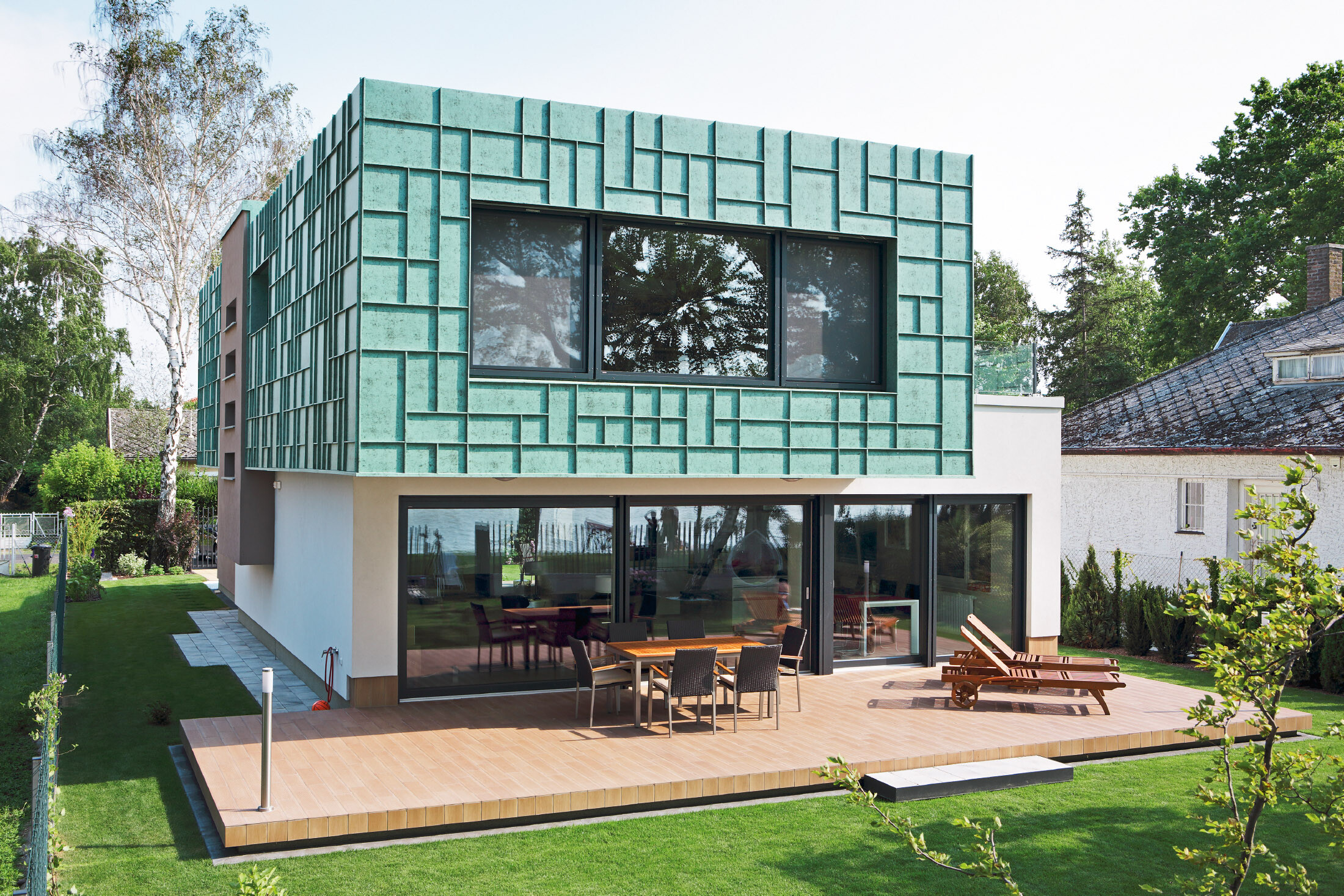 Modernes Einfamilienhaus mit sturmsicherer Fassade, die mit PREFALZ in P.10 Patina Grün verkleidet wurde.