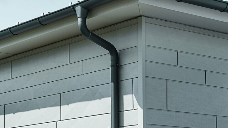 PREFA Dachrinne mit Ablaufrohr in Anthrazit dazu eine PREFA Siding.X Fassade
