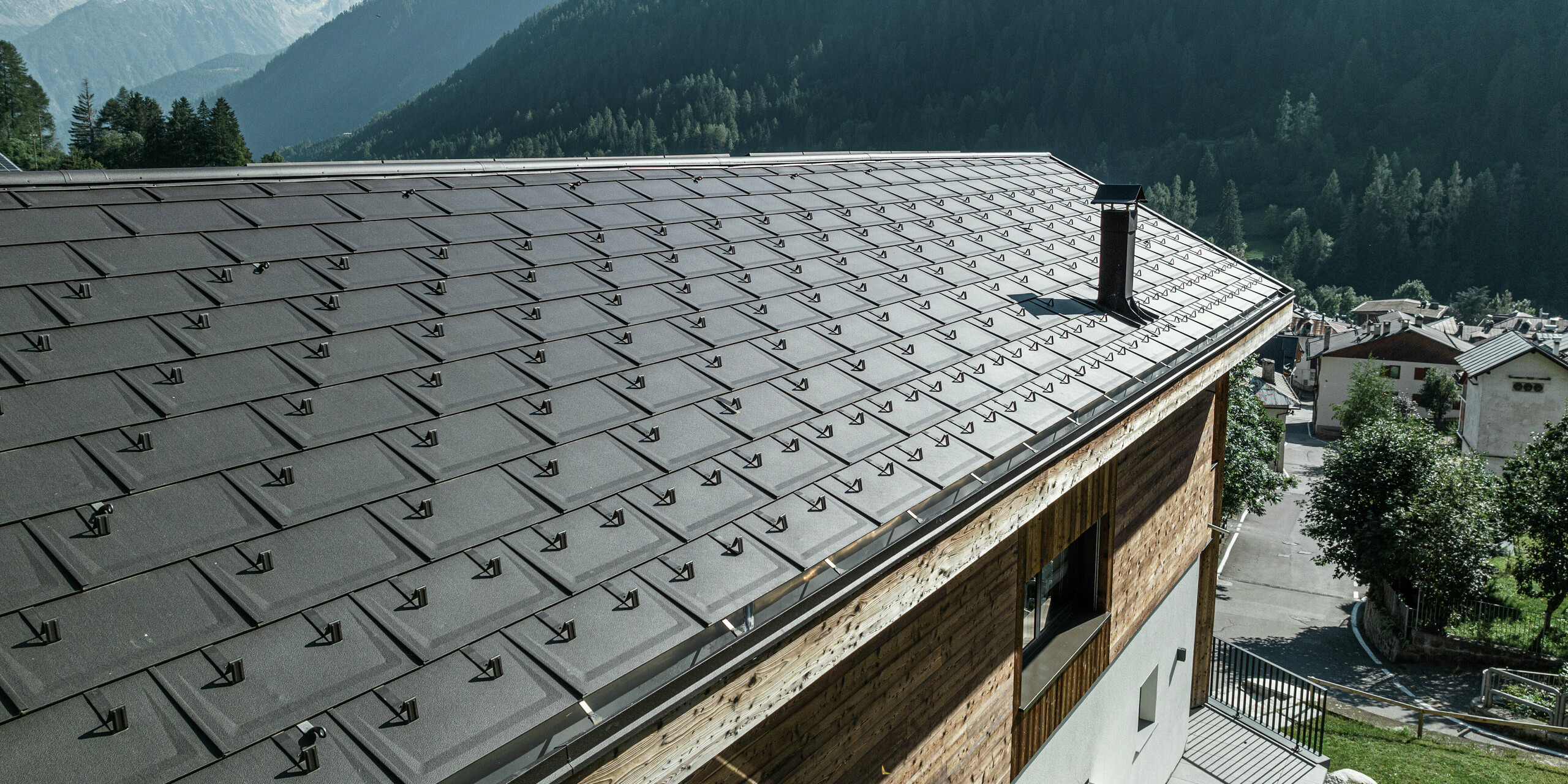 Nahaufnahme von PREFA Dachplatten R.16 in P.10 Braun verleihen dieser Berghütte in Cogolo, Val di Sol, eine stilvolle Optik und bieten auch maximalen Schutz vor extremen Witterungsbedingungen. Die langlebige Aluminiumeindeckung mit integrierten Schneestoppern sorgt für Sicherheit und Stabilität in alpinen Höhen. Ein wartungsarmes und ästhetisches Dach für Generationen.