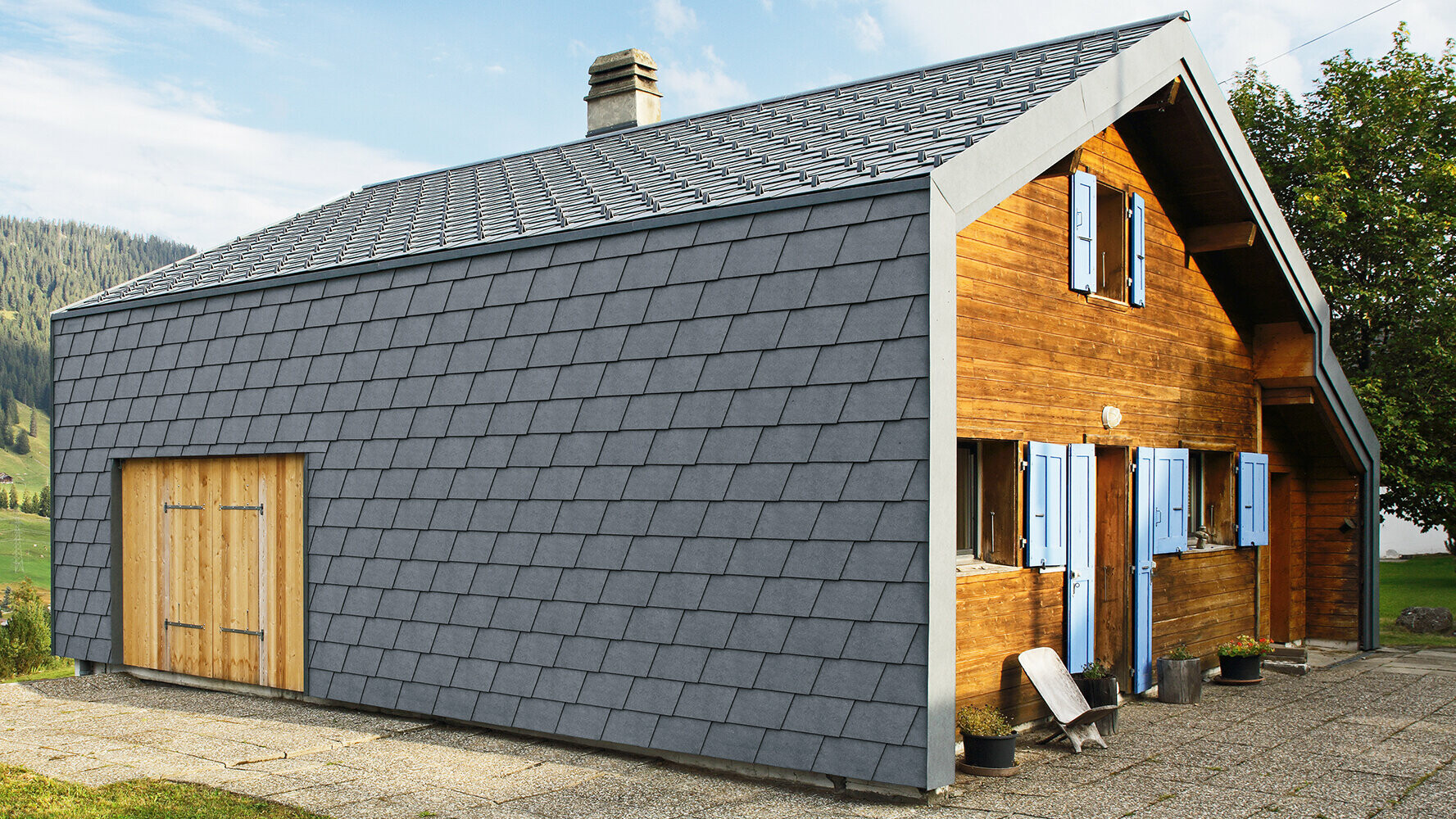Modernes Einfamilienhaus verkleidet mit PREFA Wandschindeln in der Farbe P.10 Steingrau und Holzelementen.