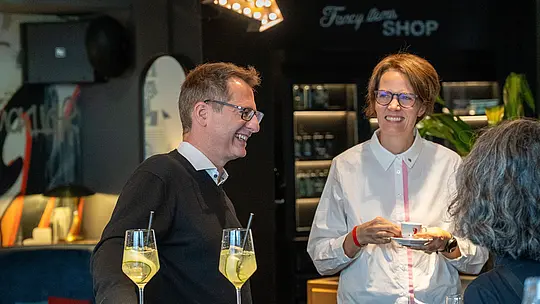 Beim PREFARENZEN Special Wien genießen Gäste den persönlichen Austausch in entspannter Atmosphäre. Zwei Teilnehmer unterhalten sich bei Getränken und Kaffee, während im Hintergrund die stilvolle Lounge mit moderner Gestaltung sichtbar wird. Das Event verbindet Networking, Architektur und nachhaltige PREFA Aluminiumlösungen, die für langlebige, vielseitige und innovative Baukonzepte stehen.