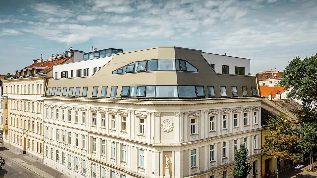 Moderner Dachausbau eines Gründerzeithauses in der Schloßhofer Straße in Wien, eingekleidet mit der Aluminium Verbundplatte in Bronze