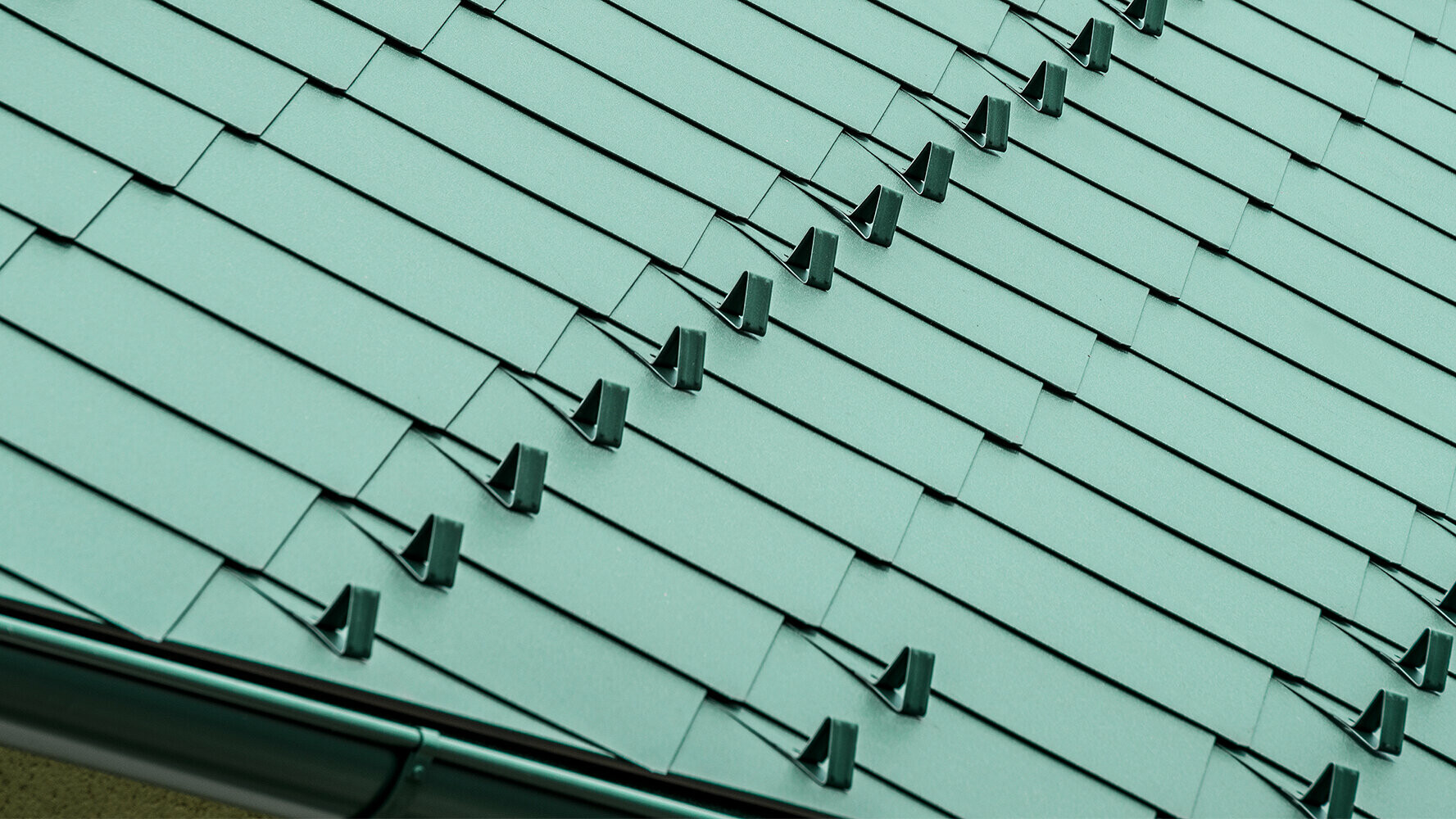 Kleines Einfamilienhaus nach der Dachsanierung mit PREFA Dachrauten 44 × 44 in P.10 Moosgrün