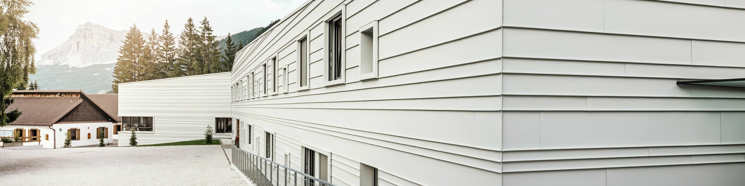 Die moderne Architektur der Kaserne „Tempesti“ setzt mit PREFALZ in der Farbe P.10 Prefaweiß ein markantes Statement. Die horizontal verlegten Aluminiumscharen sorgen für eine klare Struktur. Durch die helle Farbgebung wird Licht reflektiert, was das Mikroklima in alpiner Umgebung verbessern soll.