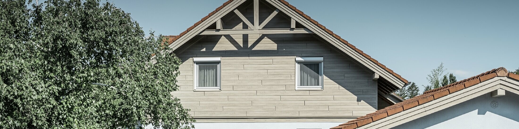 Die Aluminiumfassade in Holzoptik von PREFA wurde hier horizontal verlegt und muss nie mehr nachgestrichen werden.