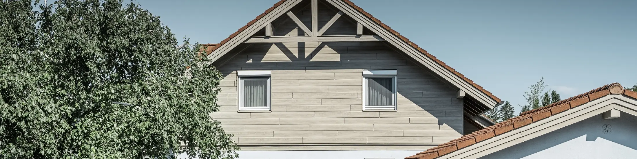 Die Aluminiumfassade in Holzoptik von PREFA wurde hier horizontal verlegt und muss nie mehr nachgestrichen werden.