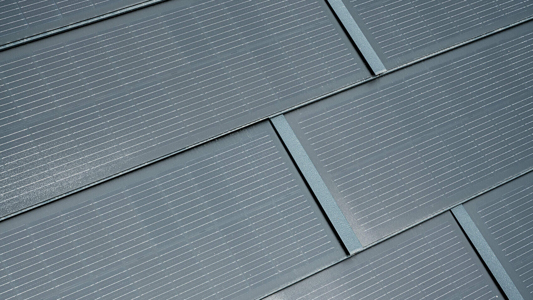 Detailaufnahme der PREFA Solardachplatte in der Farbe Anthrazit. Mit den integrierten Photovoltaik-Modulen produziert das sturmsichere Dachsystem aus Aluminium Strom aus Sonnenenergie, während es das Haus schützt.
