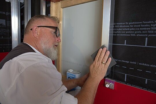 Der PREFA-Techniker schleift die Aluminiumprofile der Alu-Unterkonstruktion mit einem Schleifvlies.