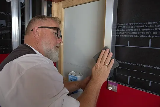 Der PREFA-Techniker schleift die Aluminiumprofile der Alu-Unterkonstruktion mit einem Schleifvlies.