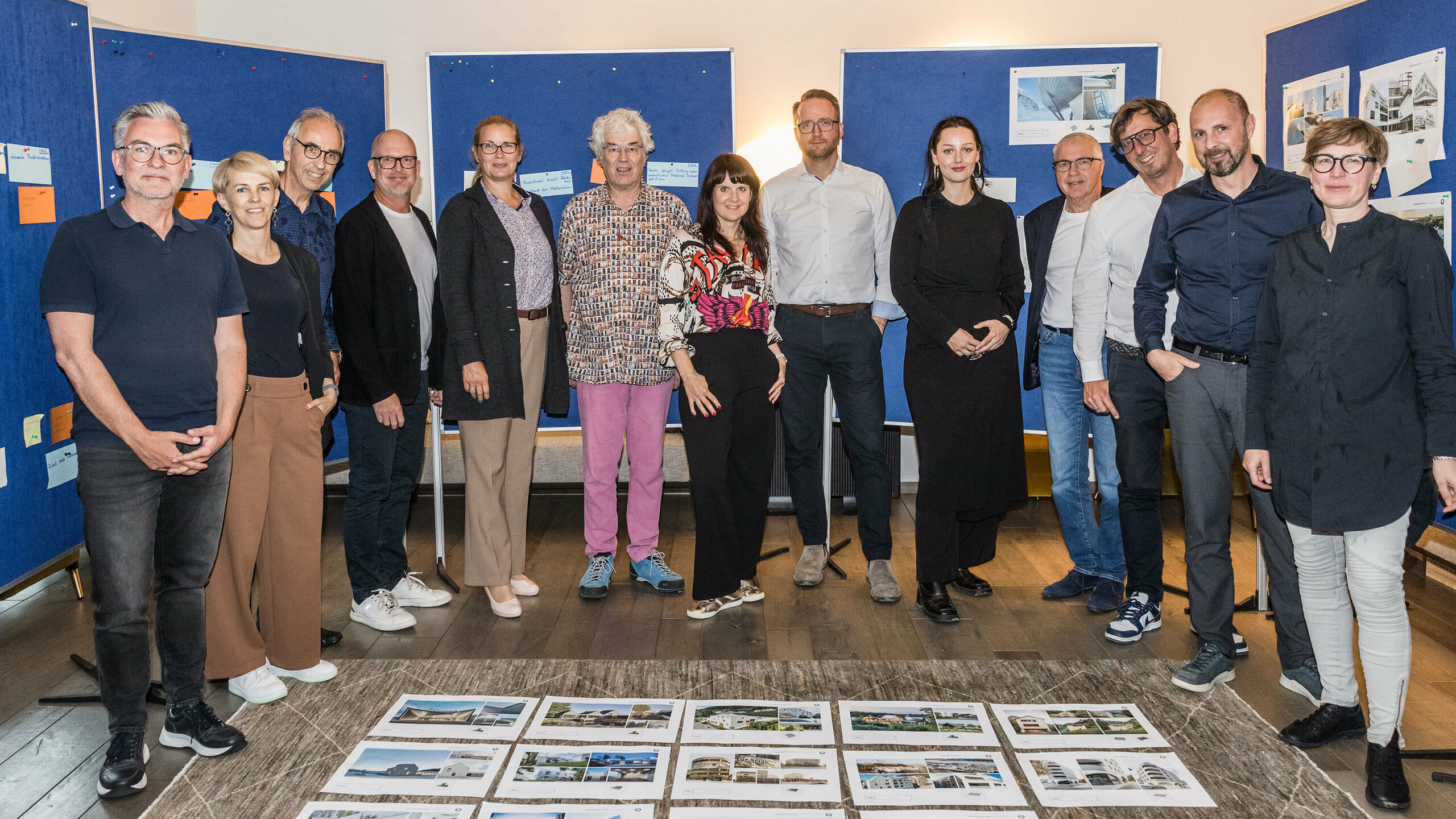 Gruppenfoto der PREFARENZEN 2026 Jury nach erfolgreichem Auswahlprozess in einer Winzerresidenz im burgenländischen Seewinkel: Die interdisziplinäre Expertengruppe bestehend aus Dirk Lorenz (Leinert Lorenz Architekten), Veronika Roll (Marketing, PREFA Österreich), Wolfgang Croce (Croce & Wir, Graz), Jürgen Jungmair (Marketingleiter International, PREFA), Judit Nemere (Geschäftsführung PREFA Ungarn), Matthias Finkentey (Moderation), Bettina Almeida (Kommunikationsmanagement, PREFA), Christian Wirth (Regionalleiter Ost, PREFA Österreich), Selina Wach (Head of Discourse, Architektur Aktuell), Thomas Schlett (B3 Architekten), Sven Disser (Leiter Development, Bauwerk), Falk Leinert (Leinert Lorenz Architekten) und Juliane Croce (Croce & Wir, Graz) steht vor den final ausgewählten Architekturprojekten für das PREFARENZEN Architekturbuch und den Kalender 2026. Die Projekte spiegeln Vielfalt, Nachhaltigkeit und innovativen Einsatz von PREFA Materialien wider.