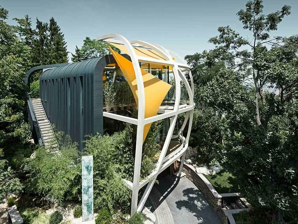 Gesamtansicht eines einzigartigen Baumhauses mit architektonischen Details und PREFA Prefalz Fassadenelementen in P.10 Anthrazit