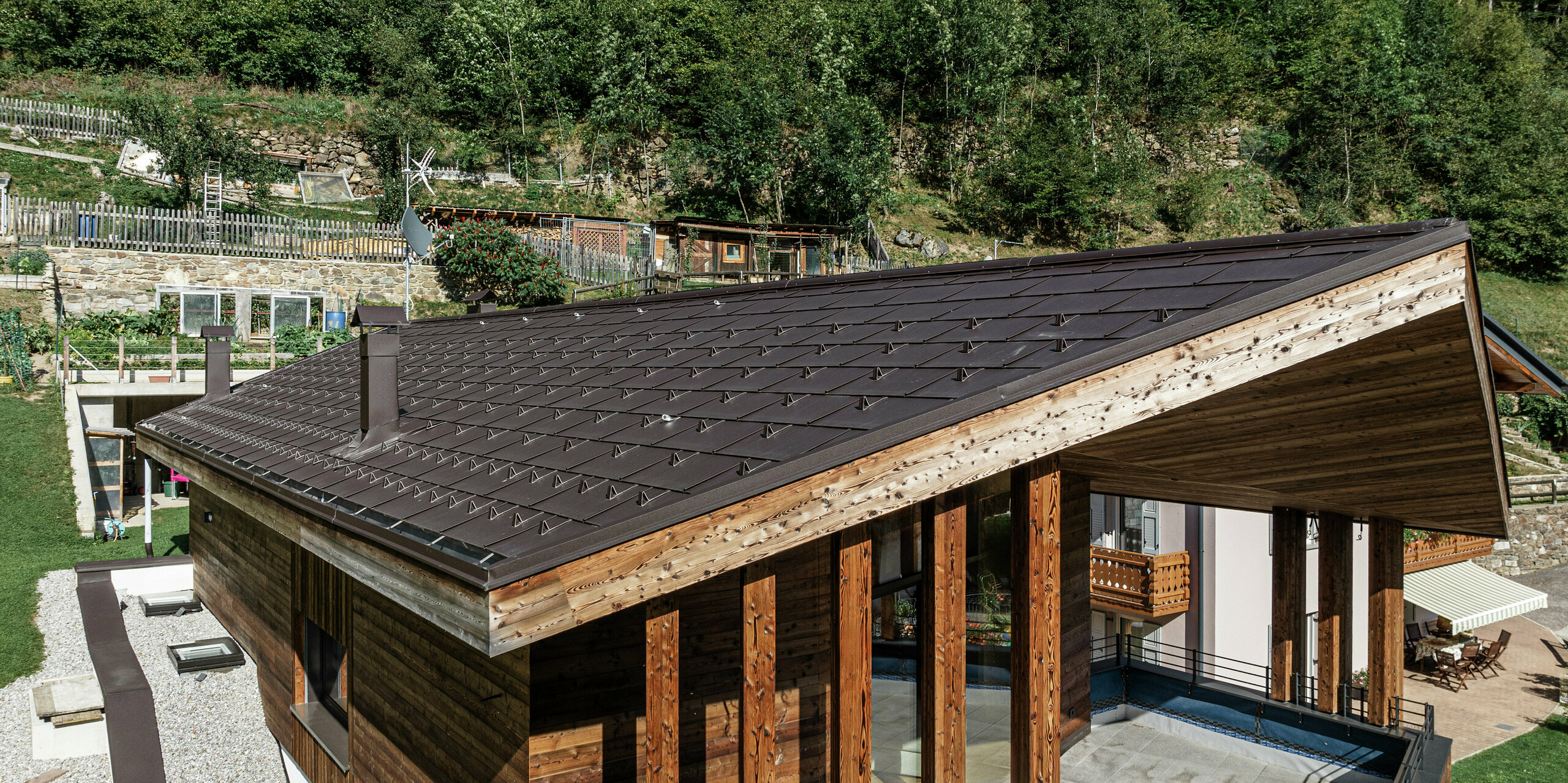 Modernes Berghaus in Cogolo im Val di Sol mit widerstandsfähigem PREFA Aluminiumdach. Die PREFA Dachplatte R.16 in P.10 Braun fügt sich harmonisch in die Holzarchitektur ein und bietet optimalen Schutz vor extremen Witterungseinflüssen. Langlebig, wartungsfrei und ideal für alpine Regionen - ein perfektes Zusammenspiel von Design und Funktionalität.