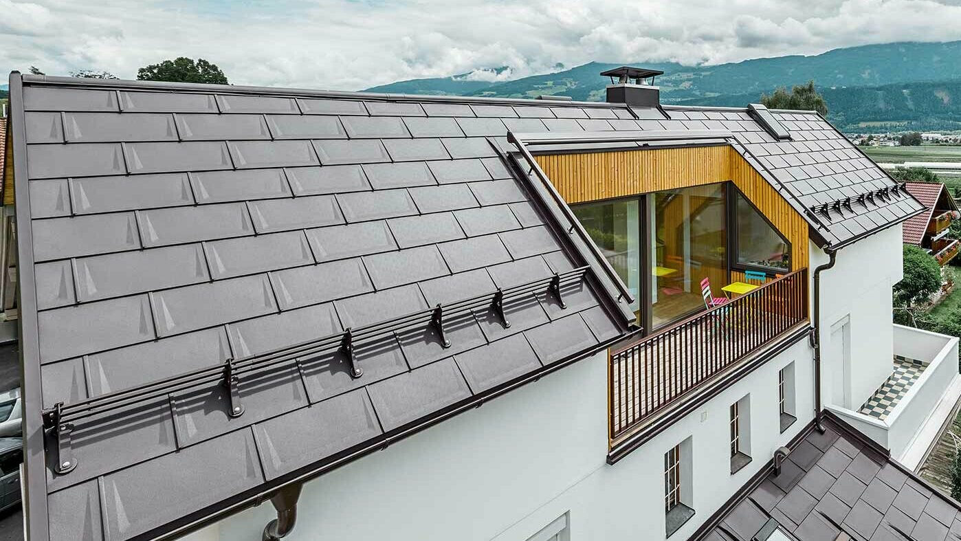 Mehrparteienhaus mit großzügiger Logia - Das Dach ist mit der PREFA Dachplatte R.16 in Nussbraun eingedeckt.