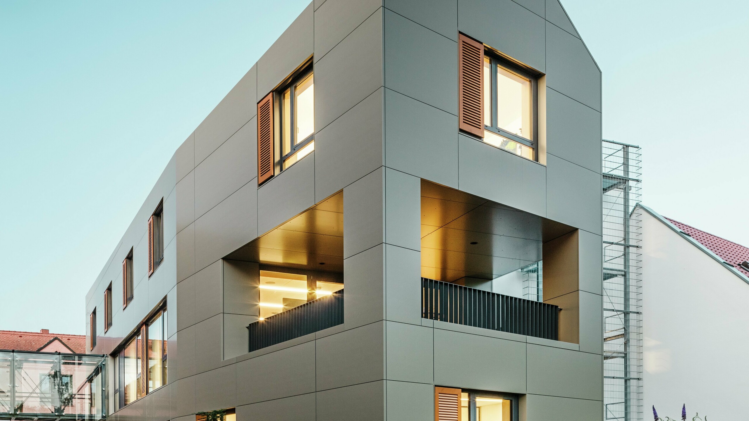 Das Rathaus in Alzenau, Deutschland, zeigt eine moderne Fassade aus Aluminium-Verbundplatten von PREFA in Bronze. Die klaren, geometrischen Linien der Platten verleihen dem Gebäude einen eleganten, zeitgemäßen Look. Der gepflegte Außenbereich ergänzt die Architektur.